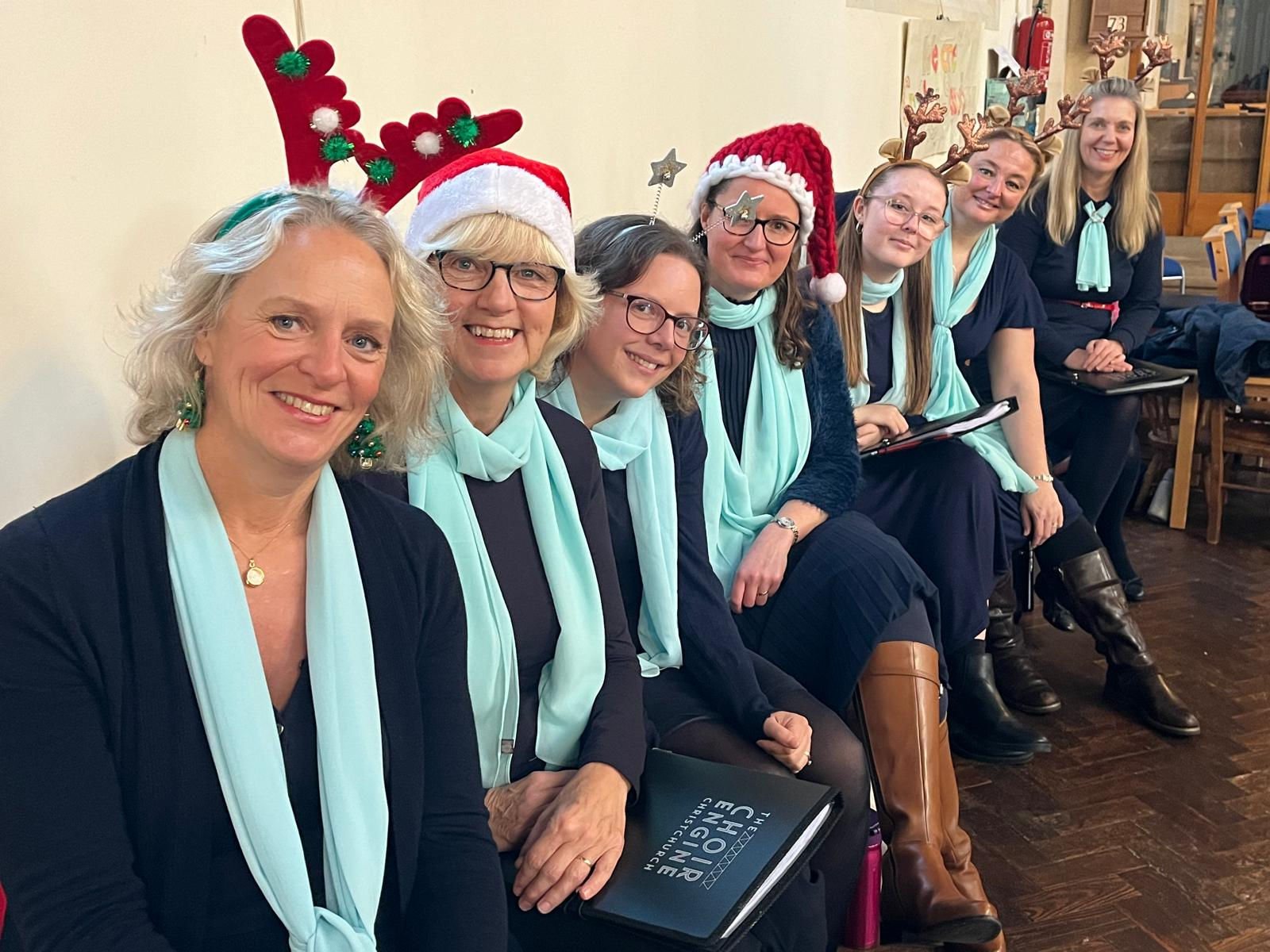 Choir members in Christmas hats and Sound Engine scarves