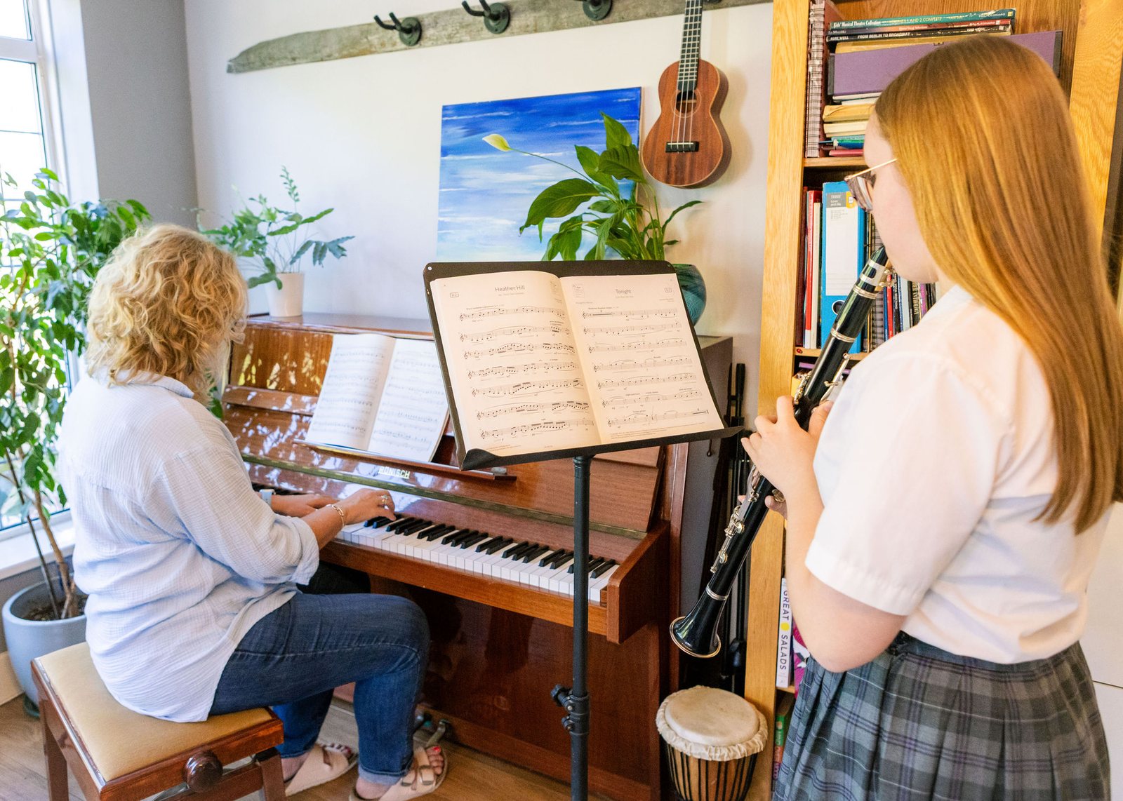 A student playing the clarinet, accompanied at the piano